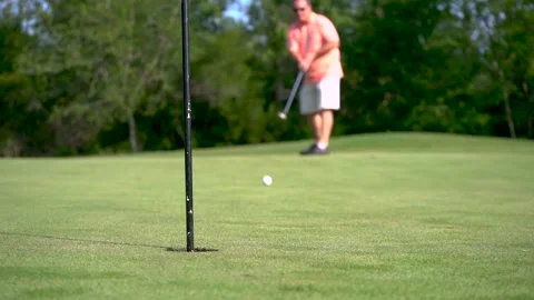 Man putting golf ball on putting green Stock Footage 135664355