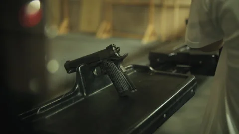 Man putting gun on shooting table, indoor shooting range Stock Footage 285729515