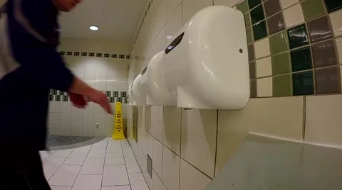 Man putting hands at warm air dryer in a public toilet Video stock 57370401