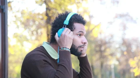 Man putting on headphones and listening to music in nature Stock Footage 59556020