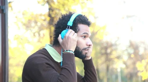 Man putting on headphones and listening to music in nature Stock Footage 59556021