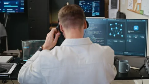 Man Putting on Headset Analyzing Cybersecurity Data in Office Stock Footage 346816290