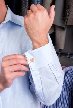 A man putting on his cuff links Stock Photos
