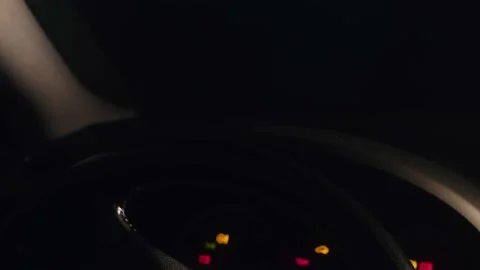 Man putting his hand on a steering wheel, preparing for a night drive. Stock Footage 145909212
