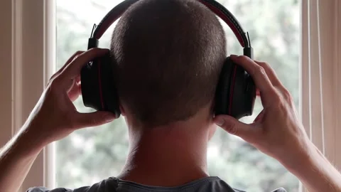 A Man Putting On His Headphones while Looking at the Rain from the Window Stock Footage 249054349