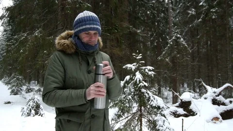 Man putting hot drink into a cup in a winter forest Stock-Footage 80207507