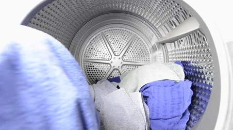 Man putting laundry in tumble dryer Stock Footage 62923245