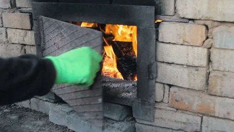 Man Putting Log into burning Stove Stock Footage 73803367
