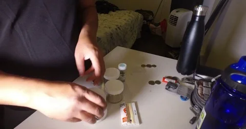 Man putting in marijuana into grinder Stock Footage