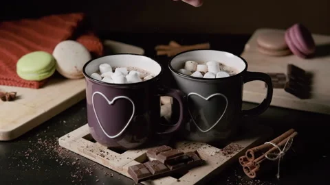 Man Putting Marshmallows into a Cup of Cocoa Video stock 166600560