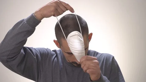 Man putting mask white background. Coronavirus Vídeos de archivo 127591121