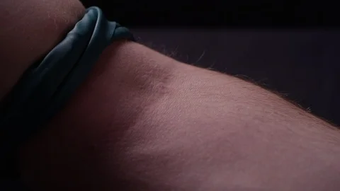 Man putting a needle into his arm, with a strap tied around his bicep Video stock 119099666
