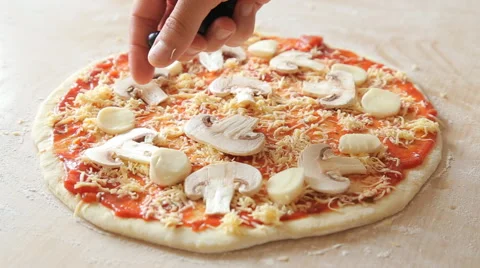 Man putting olive on pizza Stock Footage 65525974