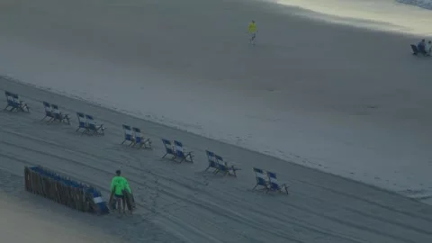 Man putting out beach chairs. Stock Footage 341876134