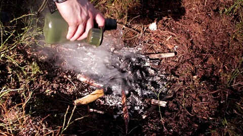 Man putting out a small camp fire Stock Footage 91708478