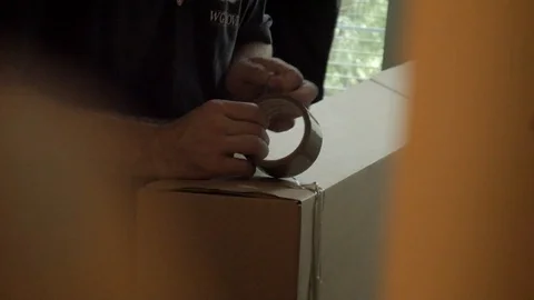 Man Putting Packing Tape On The Box Apartment Move Handheld Video stock 129499720