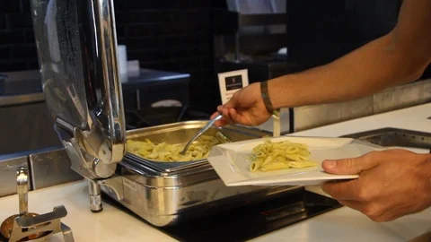 Man putting a pasta dish on a white plate Stock Footage 101243556