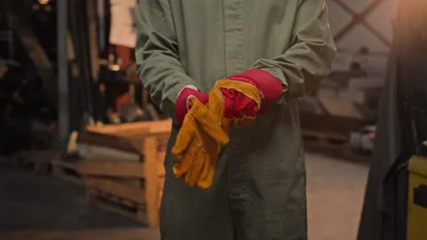 Man Putting on Protective Leather Welding Gloves in Workshop Stock Footage 342506186