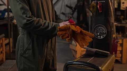 Man Putting Protective Welding Gloves on in Industrial Workshop Stock Footage 342499097