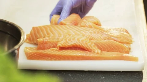 Man Putting Raw Salmon Into a Baking Tin Stock Footage 71437909