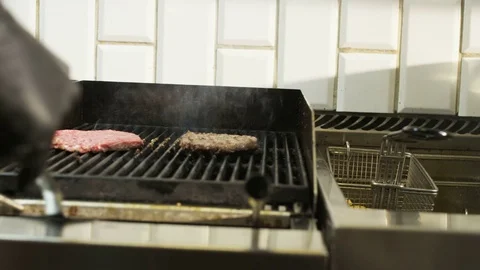 Man Putting Salami Slices on a Grill Stock Footage 71565038