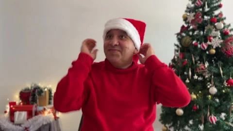 Man putting on a Santa hat smiling Stock Footage 340334652