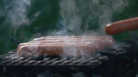 Man putting sausages on the grill Stock Footage 128398367