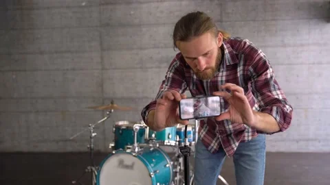 Man Putting Smartphone on a Tripod to Make Online Video of Playing Drums. Stock Footage 155554689