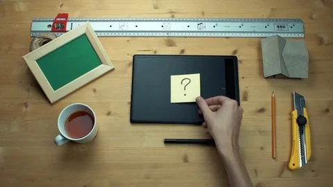 Man putting off sticky note with question sign using graphic tablet at desk Video stock 82900153