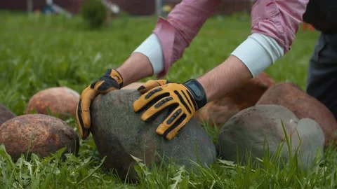 A man putting stones in a circle Stock Footage 130779476