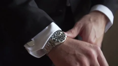 Man putting on suit jacket and watch - Groom Wedding Stock Footage 148499641