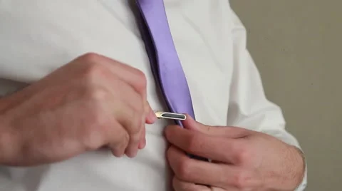 Man putting on tie clip, closeup, focused on clip Stock Footage 52190111