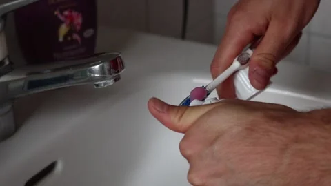 Man putting Toothpaste on Toothbrush Stock Footage 143325609