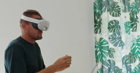 Man putting on VR goggles and experiencing virtual or mixed reality at home. Stock Footage 254812516