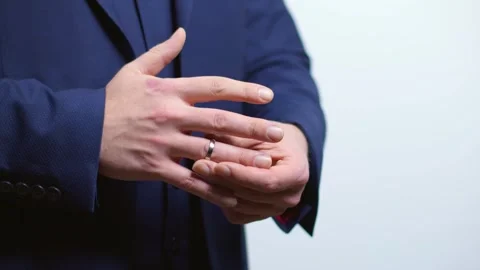 Man Putting a Wedding Ring on His Finger Stock Footage 262934980