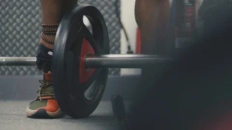 Man putting weights on an olympic bar in the gym Stock Footage 89577269