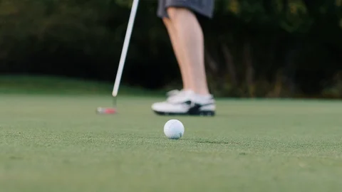 Man putts the ball into the hole close up on the hole Stock Footage 102673602