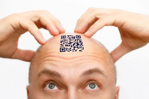 A man with a qr code on his forehead. The man looks at his QR code on his head Stock Photos