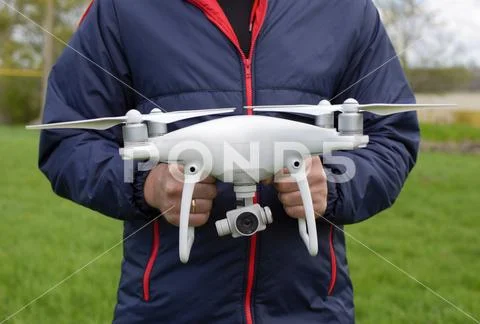 A man with a quadrocopter in his hands. A white drone is being prepared for t Stock Photos