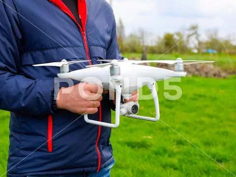 A man with a quadrocopter in his hands. A white drone is being prepared for t Stock Photos