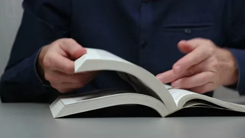 Man quickly scrolls through pages of textbook, trying find information. closeup. Stock Footage 231047881