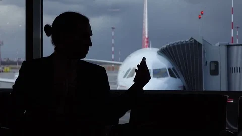 Man quickly turn head and pick up phone to check message, silhouetted view Stock Footage 77062687