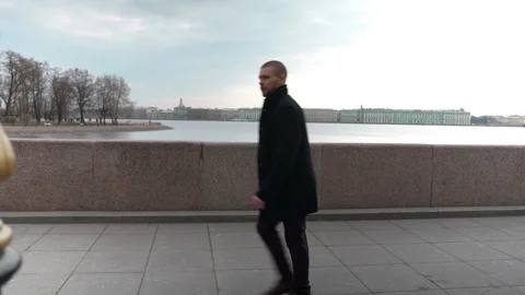 Man quickly walks forward along the road against the backdrop of beautiful city Stock Footage 129093198