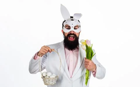 Man in rabbit mask with Easter basket eggs and flowers. Foto stock