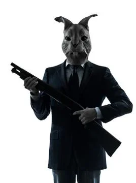 Man with rabbit mask hunting with shotgun silhouette portrait Stock Photos