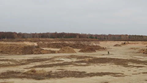 Man on a racing motorcycle rides on sandy off road and jumps across small hill. Stock Footage 142096005