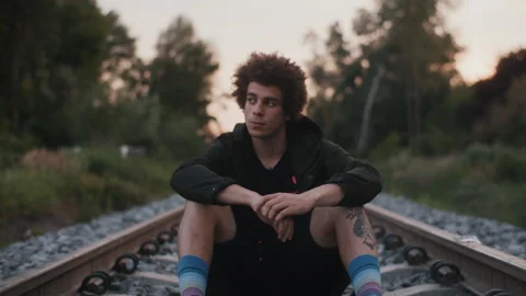 Man in the Rails Looking At Camera and Sitting Stock Footage 258352601