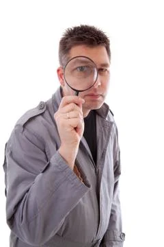 Man with raincoat is looking through magnifying glass Stock Photos