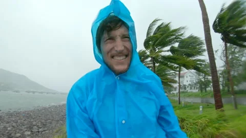A man in a raincoat is under a hevy rain and stormy wind. Shot on an action Stock Footage 144671395