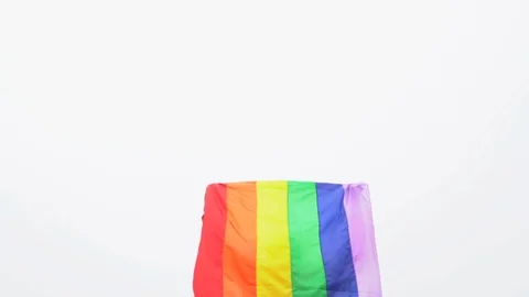 Man raise rainbow flag in hard wind Stock Footage 92407946
